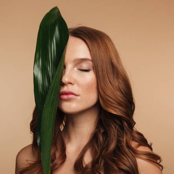 Natural brown wavy hair with green leaf beauty portrait